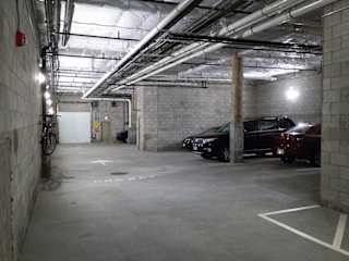 Underground parking garage with overhead pipes at 68 Beale Apartments, Massachusetts